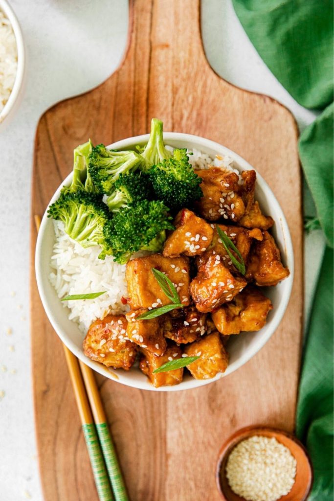 Sweet chili tofu nuggets sprinkled with white sesame seeds and freshly-sliced green onion.