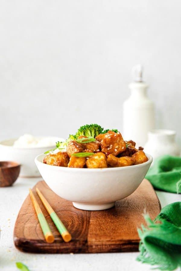Crispy air fryer sweet chili tofu served in a bowl with white rice and broccoli.