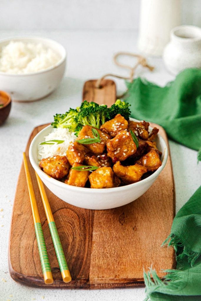 Air fryer sweet chili tofu served in a bowl with chopsticks.