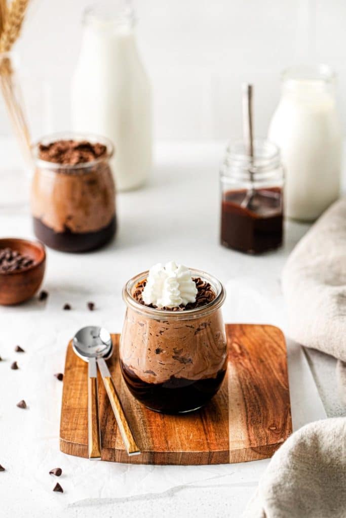 A mini chocolate mousse trifle garnished with chocolate shavings and a dollop of whipped cream.