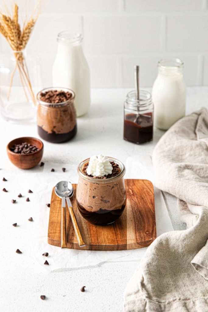 Chocolate trifle dessert served in small glass jars for individual portions.