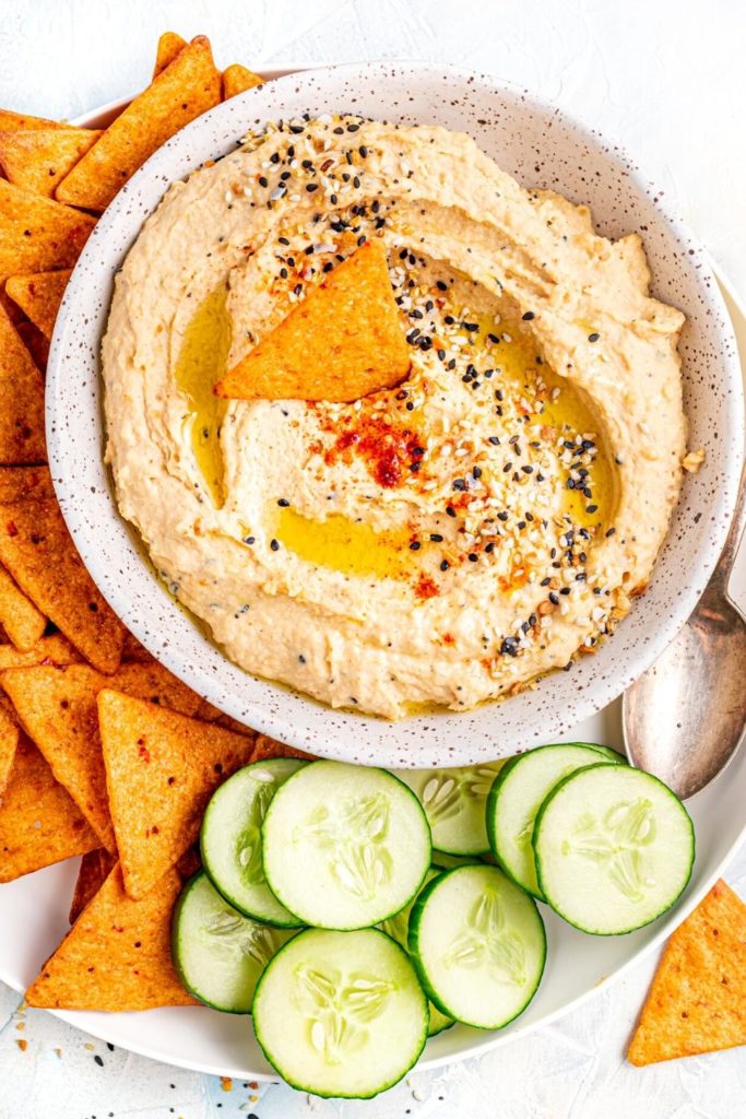 Everything Bagel Hummus drizzled with olive oil and sprinkled with seasoning. Served with cucumbers and crackers.