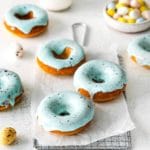 Easter Donuts with blue robin's egg glaze and brown speckled spots on a metal rack.