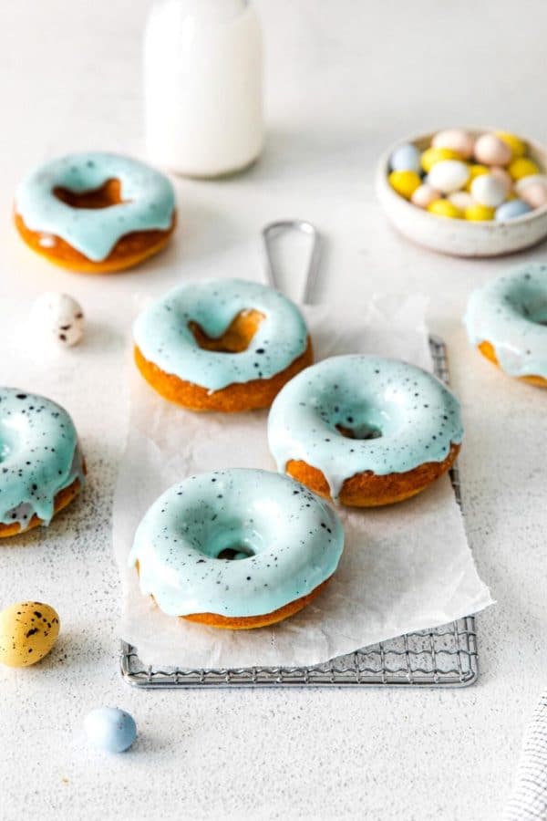 Easter Donuts with blue robin's egg glaze and brown speckled spots on a metal rack.