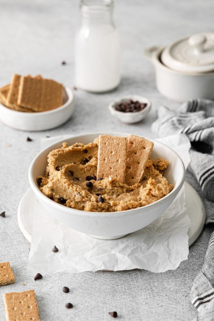 Cookie dough hummus made with chickpeas served in a dip bowl with graham crackers.