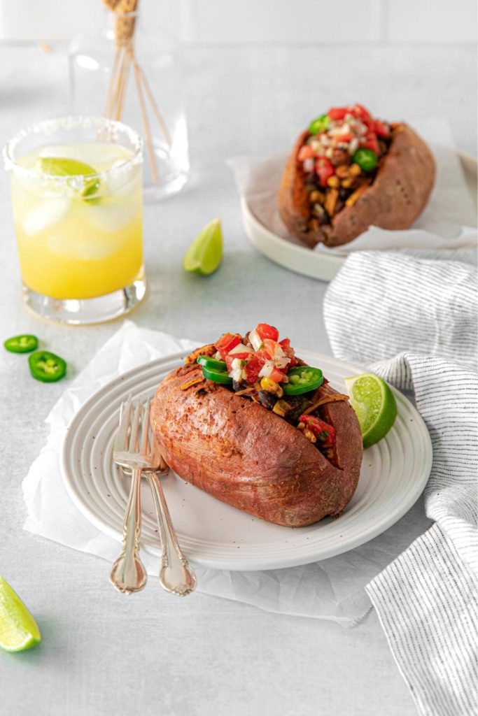 Mexican stuffed sweet potato: baked and loaded with vegetarian taco filling and garnishes.