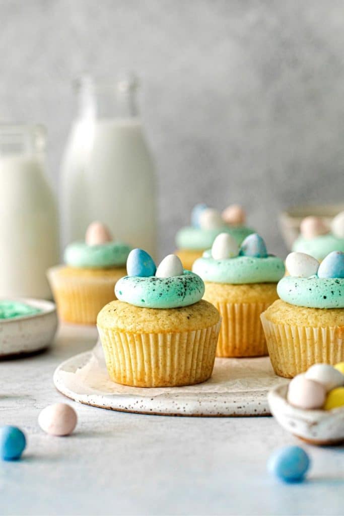 Easter egg cupcakes for toddlers on a dessert table with mini Cadbury eggs and milk.