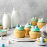 Five robin's egg easter cupcakes with buttercream frosting swirled into birds' nests with mini Cadbury eggs.
