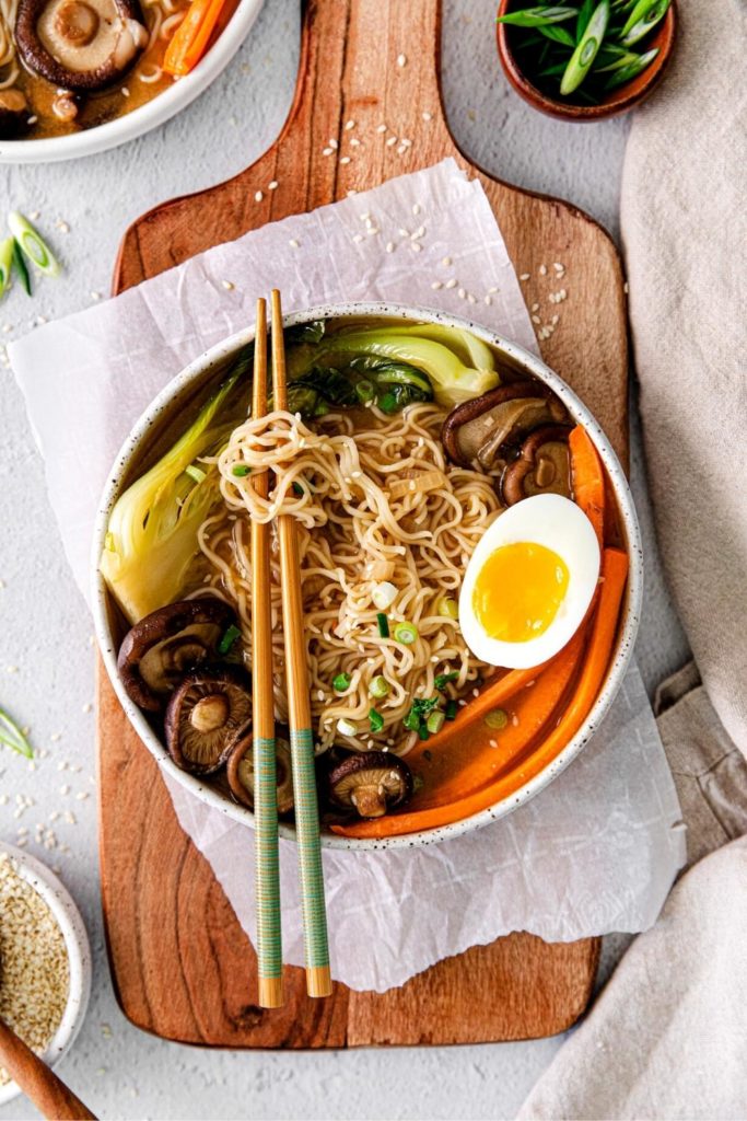 Noodles twisted around chopsticks over a ramen bowl.