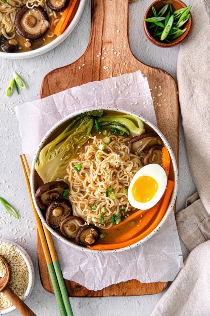 Ramen noodle bowl with a pair of chopsticks beside it.