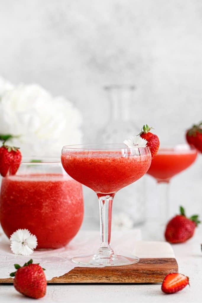 Frosé served in cocktail glasses with fresh strawberry garnishes.