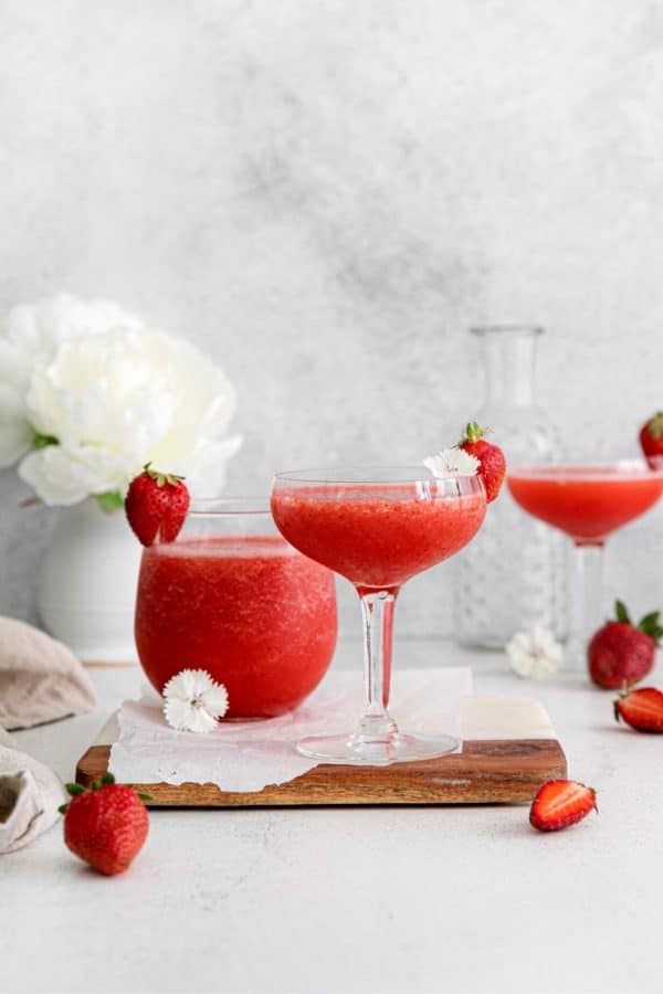 Three glasses of frozen rosé with strawberries on a serving table.