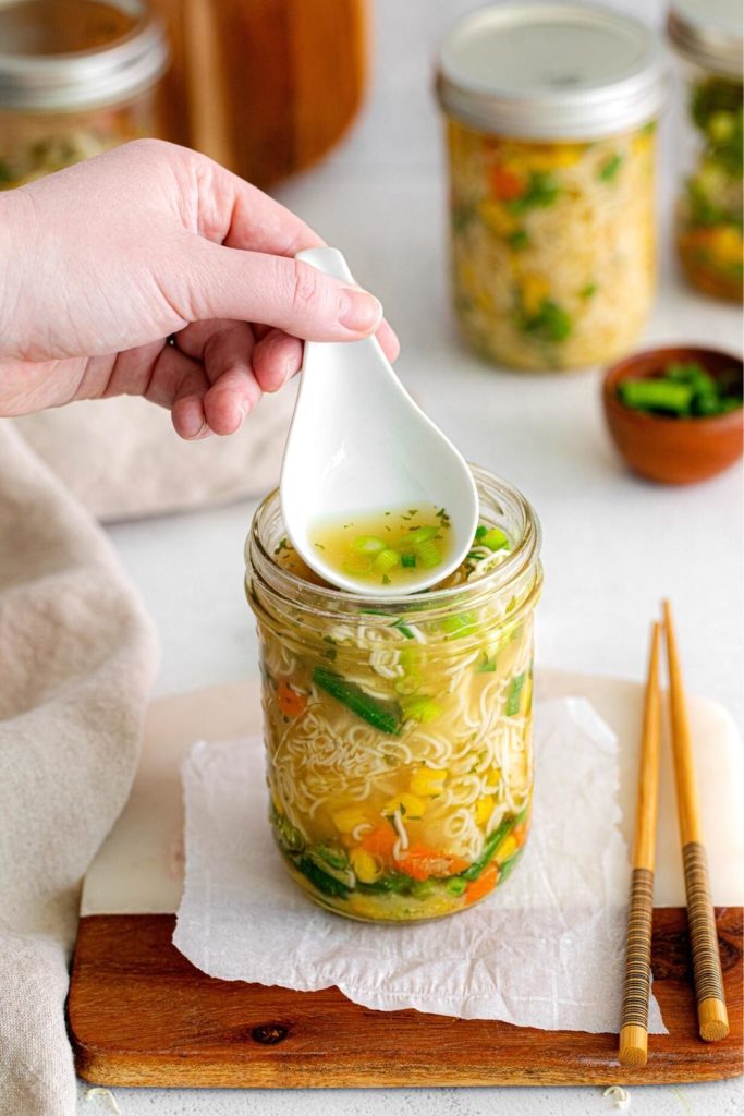 Japanese soup spoon dipping into DIY Ramen Cup of Noodles from a mason jar.