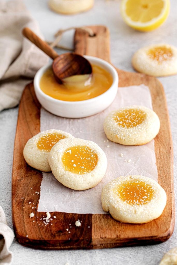 A fresh batch of Lemon Thumbprint cookies cooling sprinkled with powdered sugar.