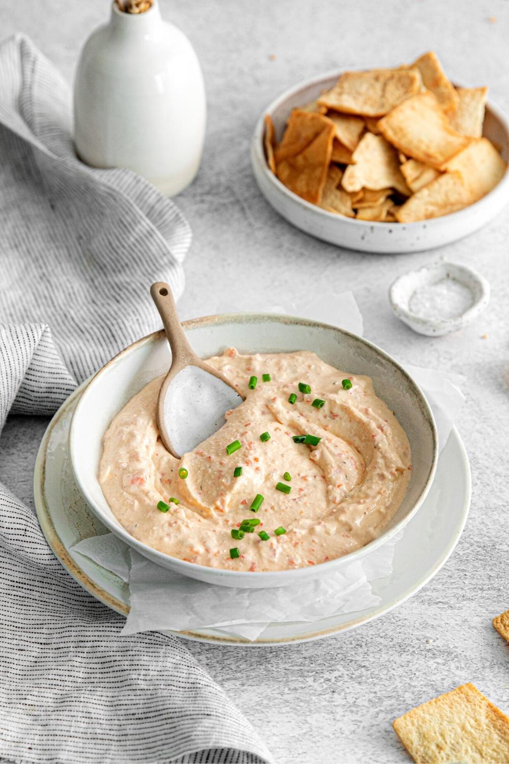 Greek whipped feta dip with roasted red pepper in a small serving bowl with spoon.