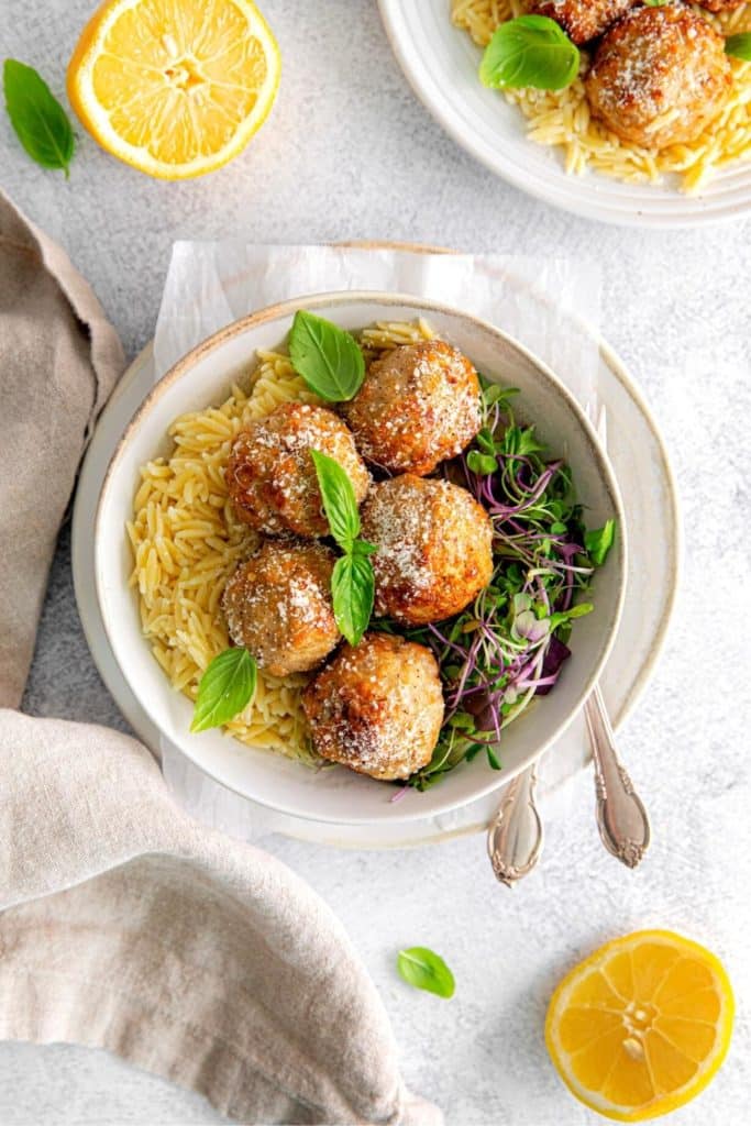 Overhead view of air fryer chicken meatballs with lemon brown butter sauce served with orzo.