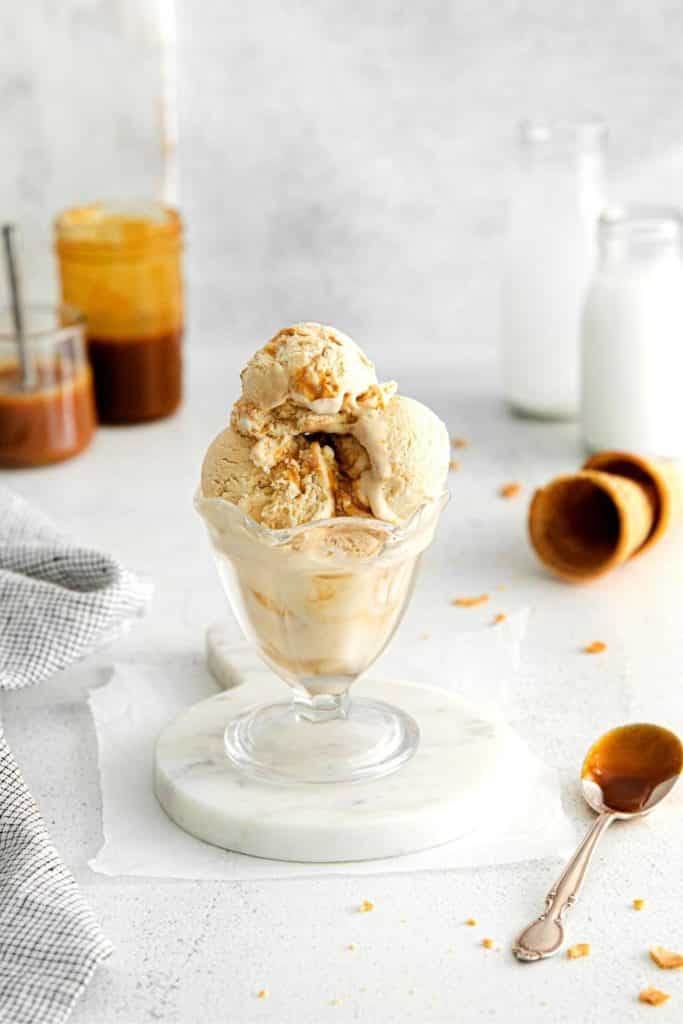 Sea Salt Caramel Ice Cream in a fluted glass ice cream dish with spoon.