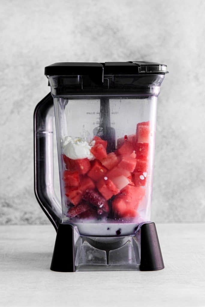 Blender jar with ingredients for a watermelon berry smoothie.