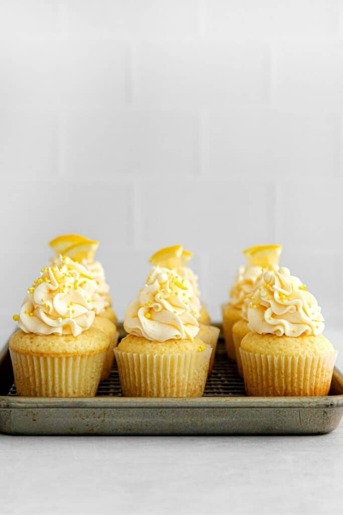 Frosted lemon cupcakes on a metal tray ready to be served.