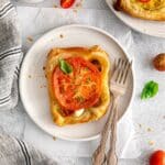 One heirloom tomato tart on a plate with 2 forks.