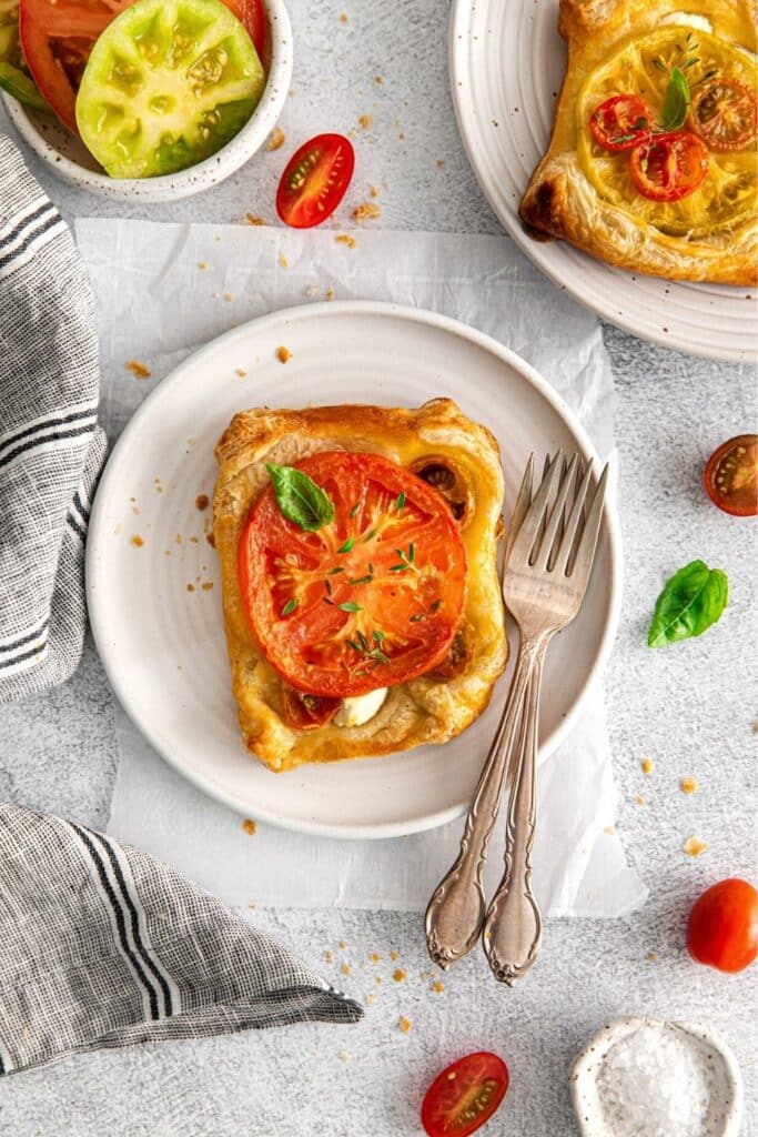 One heirloom tomato tart on a plate with 2 forks.
