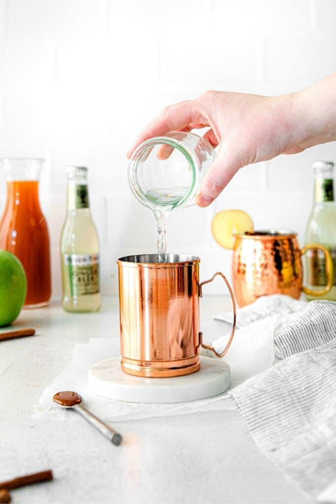 Caramel Apple Moscow Mule being assembled in a copper mug.