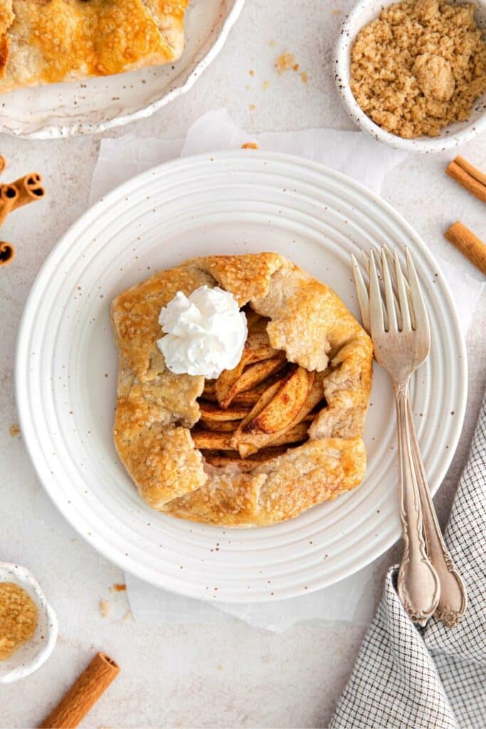 Overhead view of rustic apple galette on a plate with 2 silver forks.