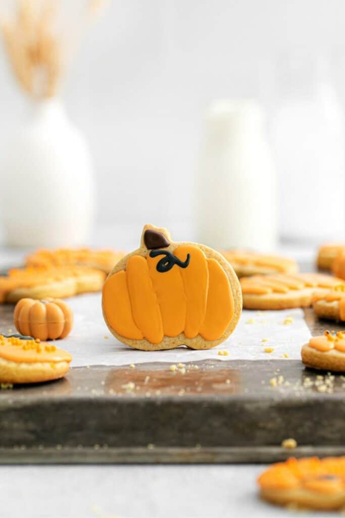 One pumpkin sugar cookie on a baking tray.