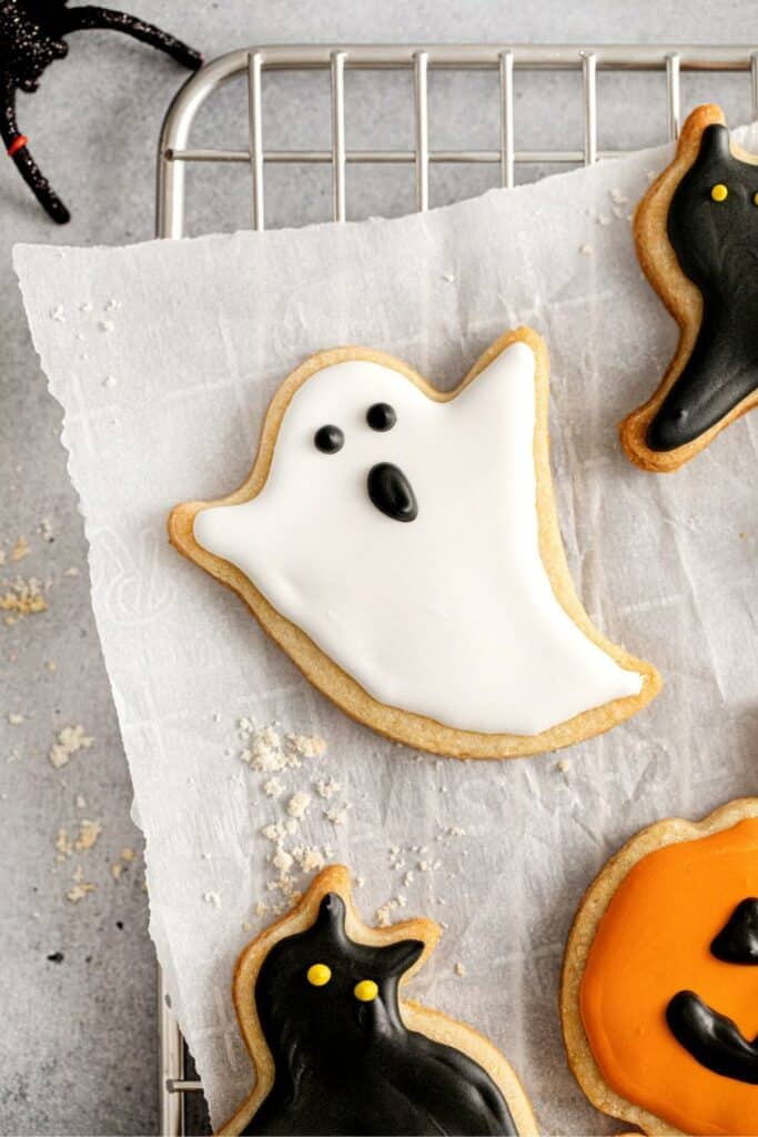 Halloween cookies in cut-out shapes decorated with royal icing.