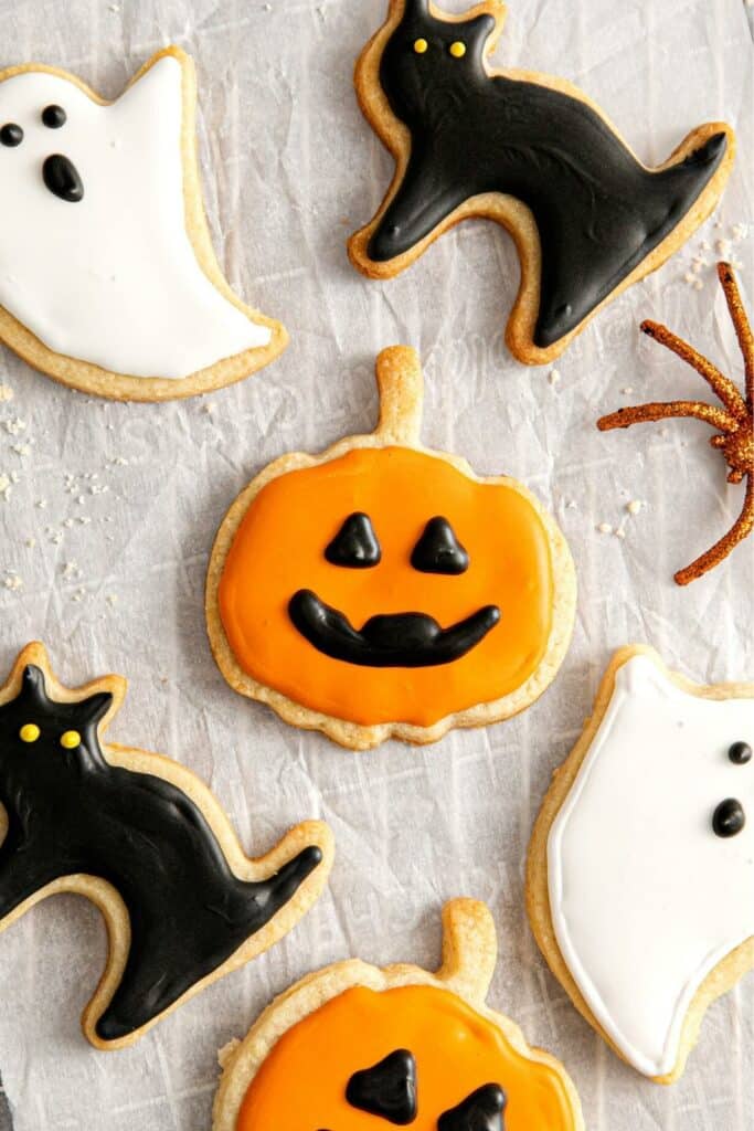 Frosted Halloween sugar cookies in orange, black and white for pumpkins, cats and ghosts.