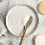 Bowl of white royal icing with a spoon.