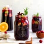 Christmas Sangria in mason jars garnished with sprigs of rosemary and whole star anise.