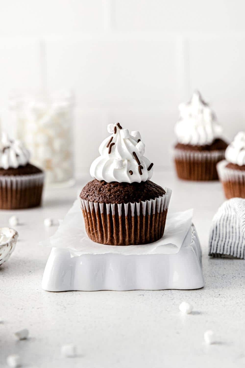 Hot chocolate cupcake with tall spirals of glossy marshmallow frosting.