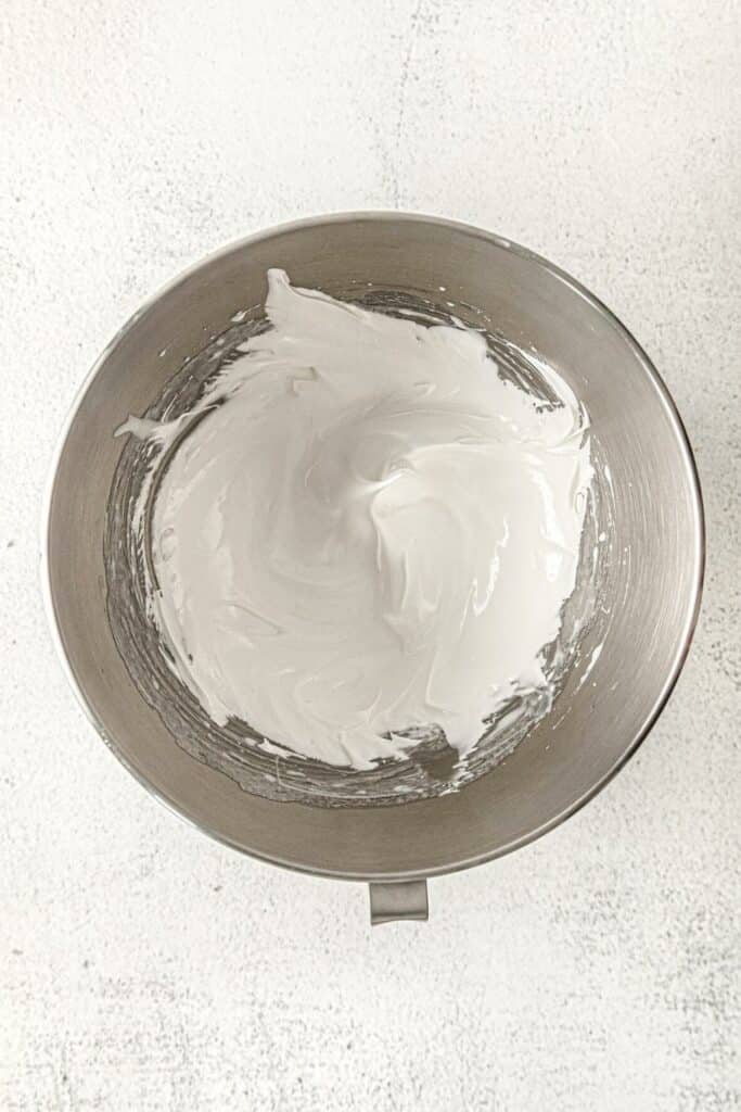 Whipped marshmallow frosting in a metal bowl.
