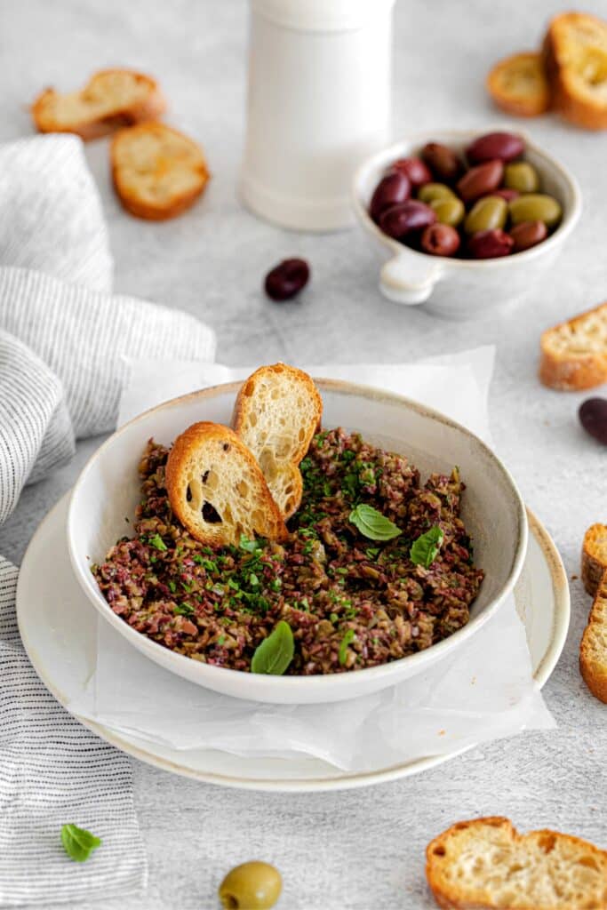 Olive tapenade served with grilled slices of rustic baguette.