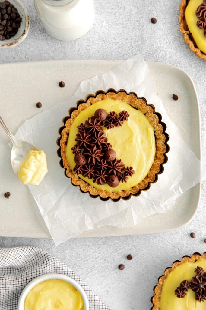 Boston cream pie desserts made with vanilla pastry cream and ganache in flaky tartlet shells.
