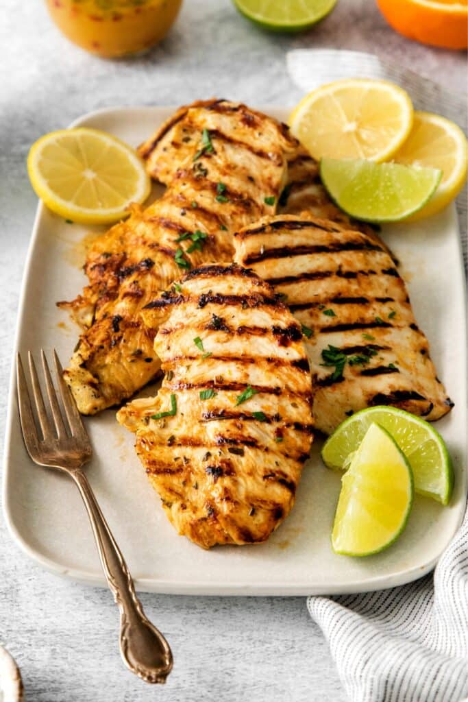 Platter of grilled chicken breasts infused with Mexican flavors from a citrus marinade.