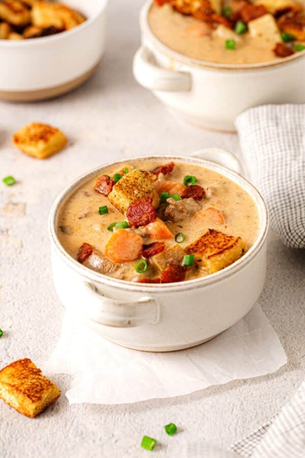 Individual serving of cheeseburger soup garnished with crispy bun croutons.