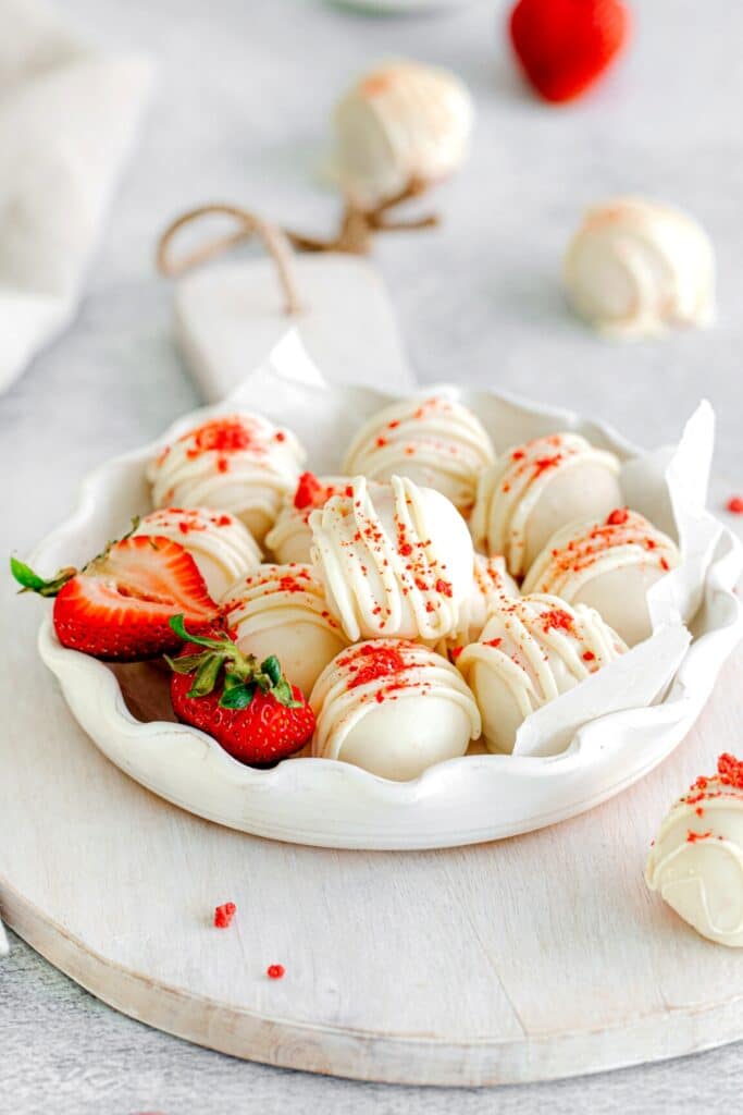 Cake truffles decorated with zig-zag drizzles of white chocolate over the coating of the cake balls.