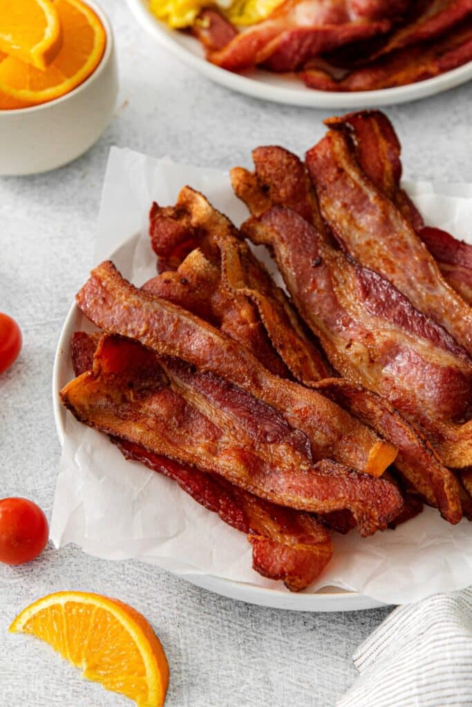 Crispy strips of air fryer bacon on a serving plate.