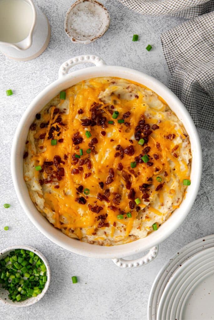 Twice baked mashed potatoes garnished with cheese, bacon and sliced green onion.