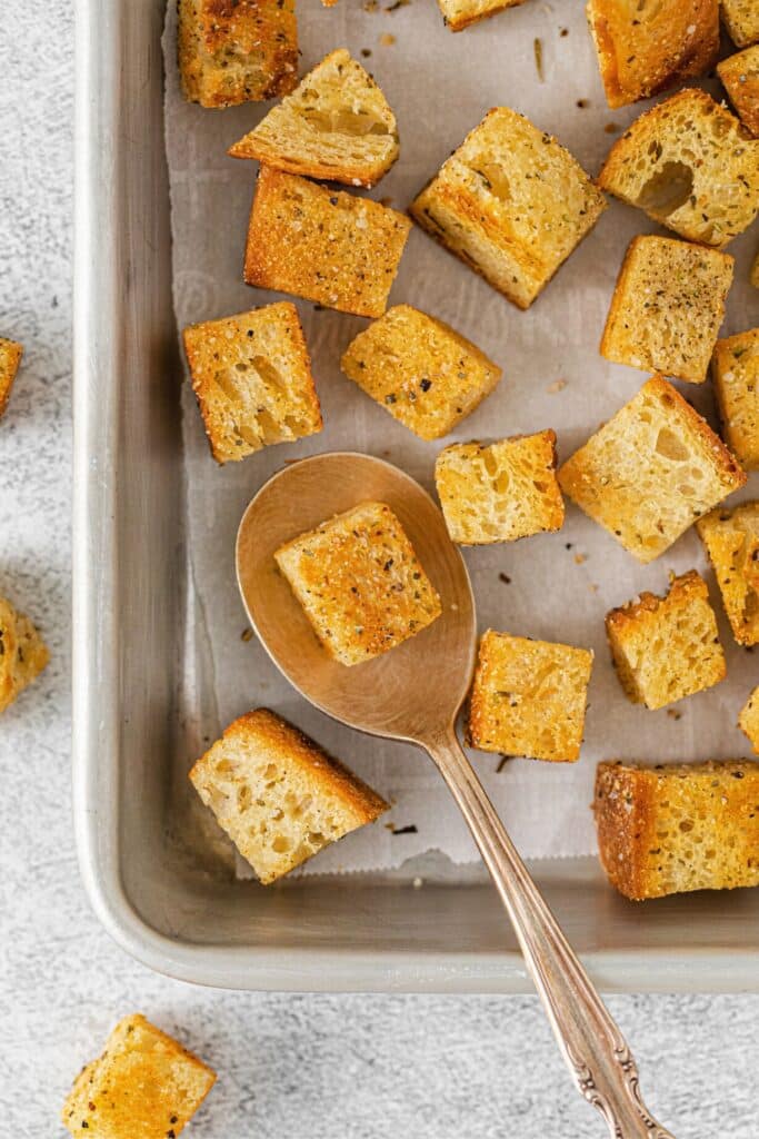 Mini sourdough croutons on a lined baking tray.