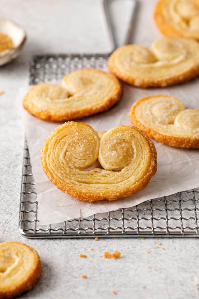 A close-up view of perfect palmier cookies cooling on a wire rack.