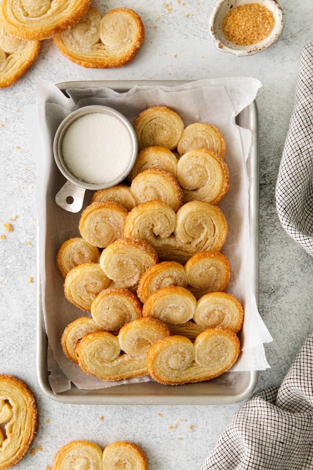 Palmiers Cookies on a baking tray with coarse sparkling sugar.