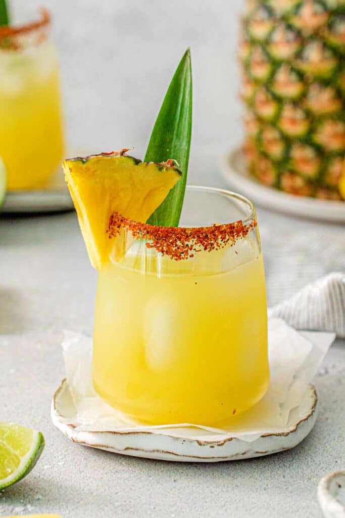 Close-up view of a pineapple Margarita garnished with a pineapple wedge and frond.