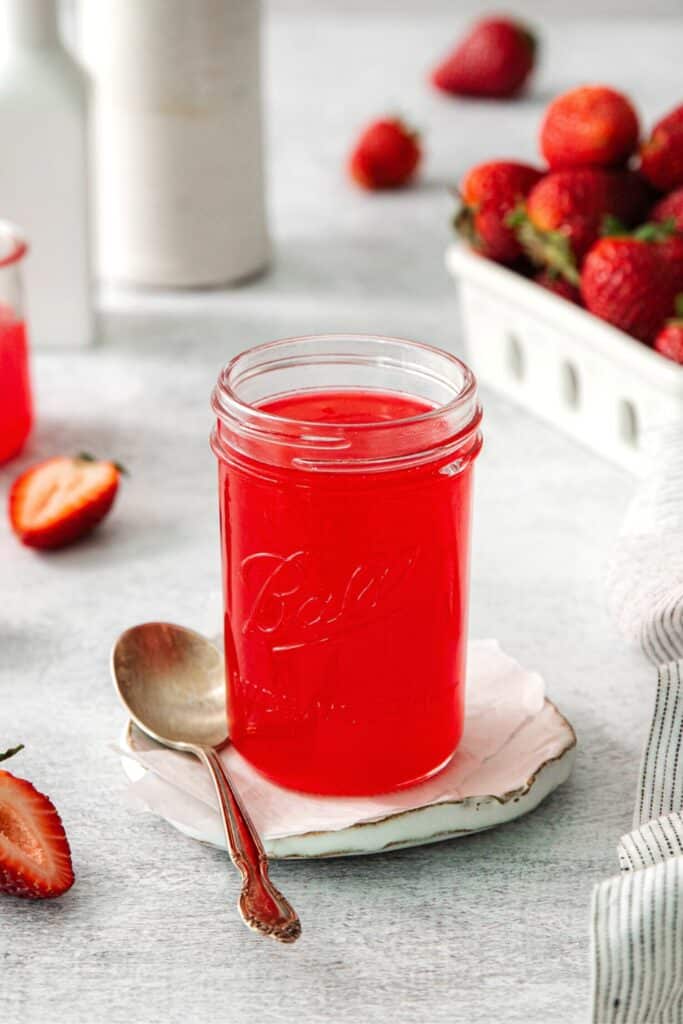 Homemade strawberry glaze in a mason jar.