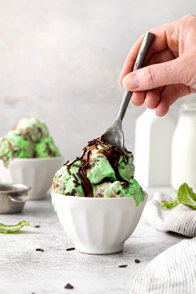 Spoon in hand, scooping a serving of no-churn mint chip ice cream.