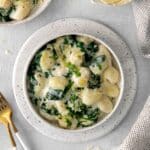 A serving of creamy parmesan spinach gnocchi on a dinner table.