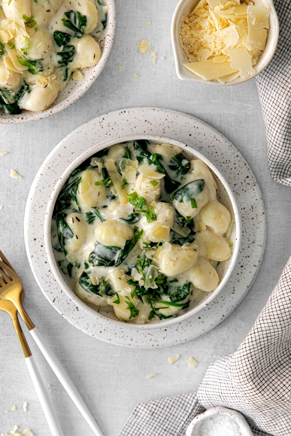 A serving of creamy parmesan spinach gnocchi on a dinner table.