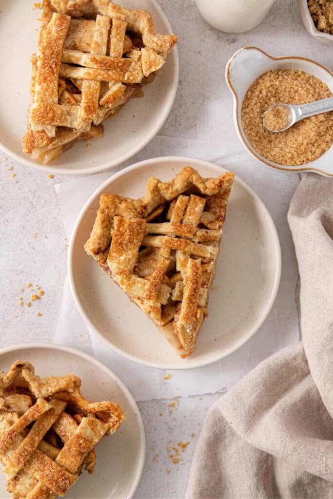 Three slices of homemade apple pie on dessert plates.
